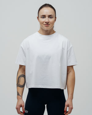 Person wearing a plain white t-shirt against a neutral background