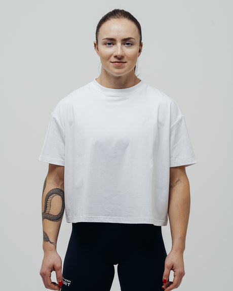 Person wearing a plain white t-shirt against a neutral background