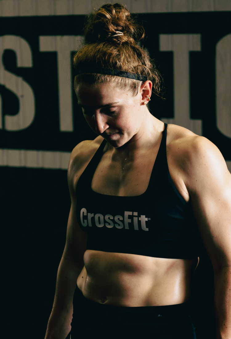 Person wearing a CrossFit sports bra in front of a black and white background